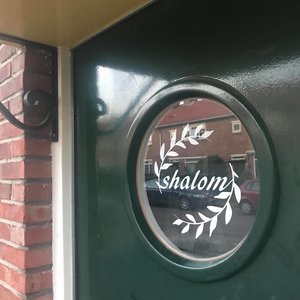 Shalom (=vrede) raamsticker gespiegeld, leesbaar vanaf de buitenkant raam