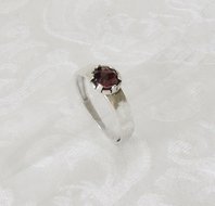 Handgemaakte ring van iets gehamerd zilver met een garnet steen.