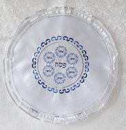 Mooie neutrale Matze cover van satijn met in blauw/zilver geborduurd het Hebreeuwse woord Pesach en de 6 elementen van een Sede