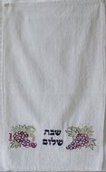 Gastendoekje van Yair Emanuel met borduursel van druiventrossen en de tekst Shabbat Shalom in het Hebreeuws.