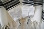 Tallit (gebedsmantel) gemaakt van 100% wol in wit/zwart compleet met de blauwe Tzitzit draadjes aan de 4 hoeken.